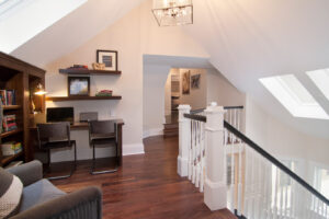 Upstairs landing with reddish hardwood flooring and white walls. From a Minneapolis home remodeling and renovation company.