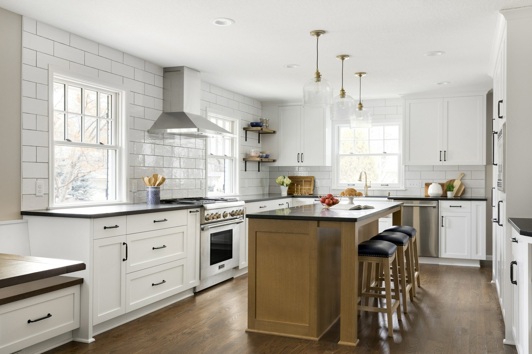 Minnesota kitchen remodel with gold light fixtures, white tile backsplash, and wood island—part of the Parade of Homes Remodelers Showcase. 