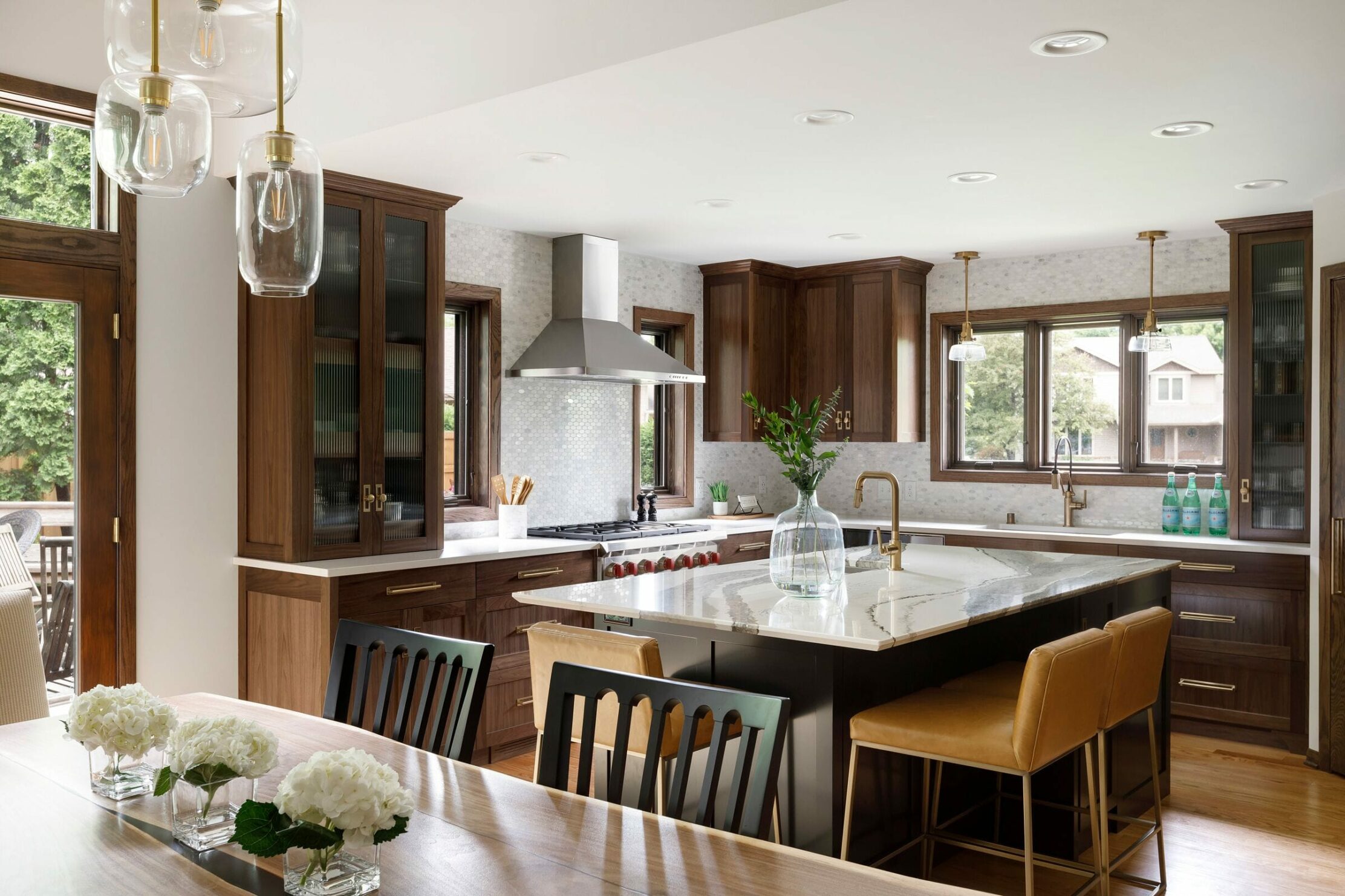 Minnesota kitchen remodel part of Parade of Homes MN Remodelers Showcase with brown cabinetry and gold and glass light fixtures.