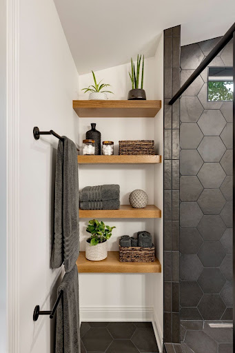 Shelf in bathroom with towels and plants incorporating bathroom trends
