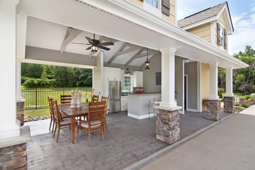 an outdoor kitchen area with a dining room and roof