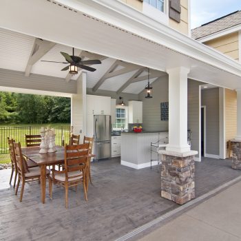 an outdoor kitchen area with a dining room and roof