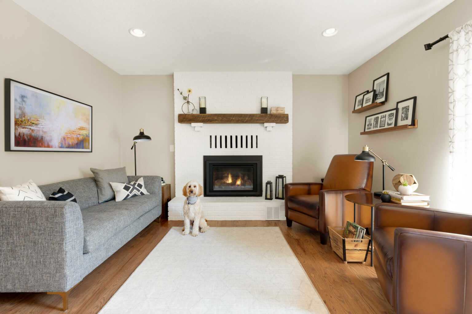 Living room with fireplace, couch, and open shelf.