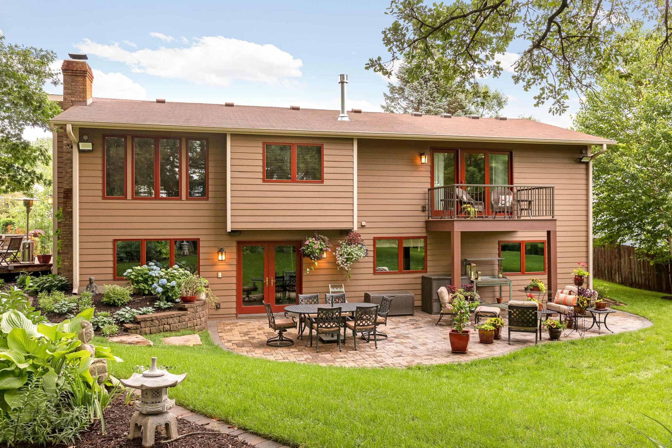 Backyard remodel with landscaped yard and chairs.