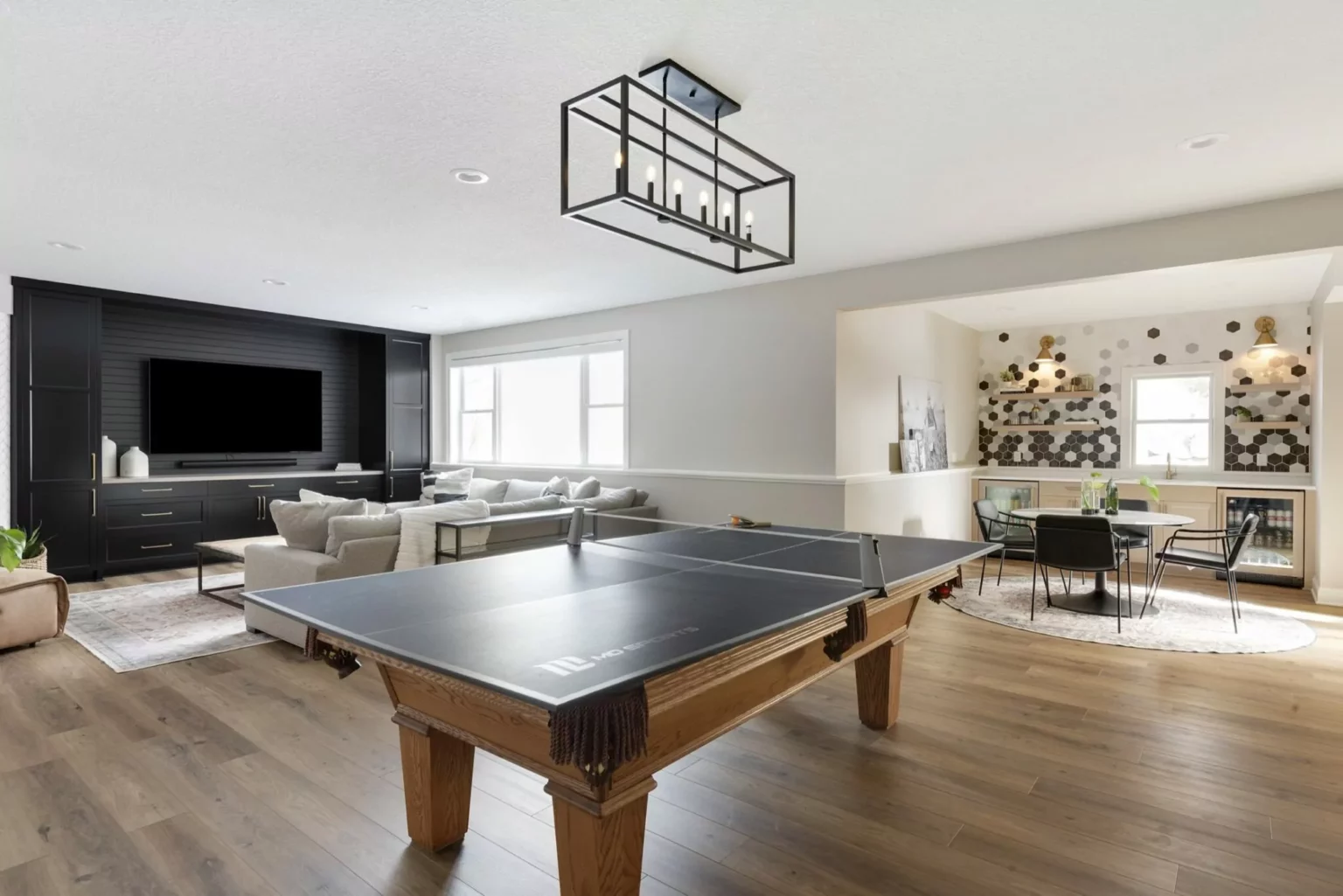 Lower level remodel with a black entertainment center and bar.