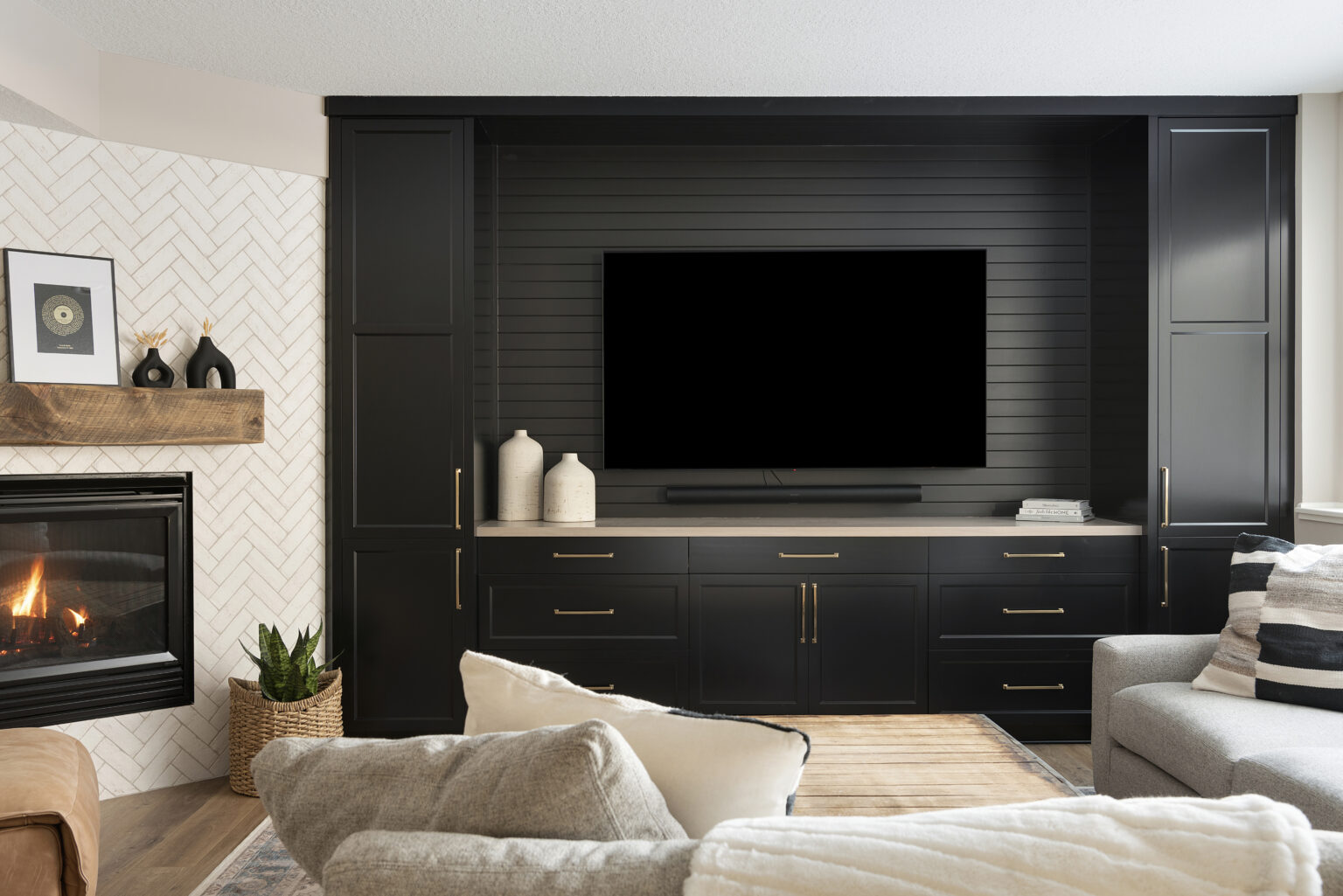 Home theater with a TV against a black wall, with white accents.