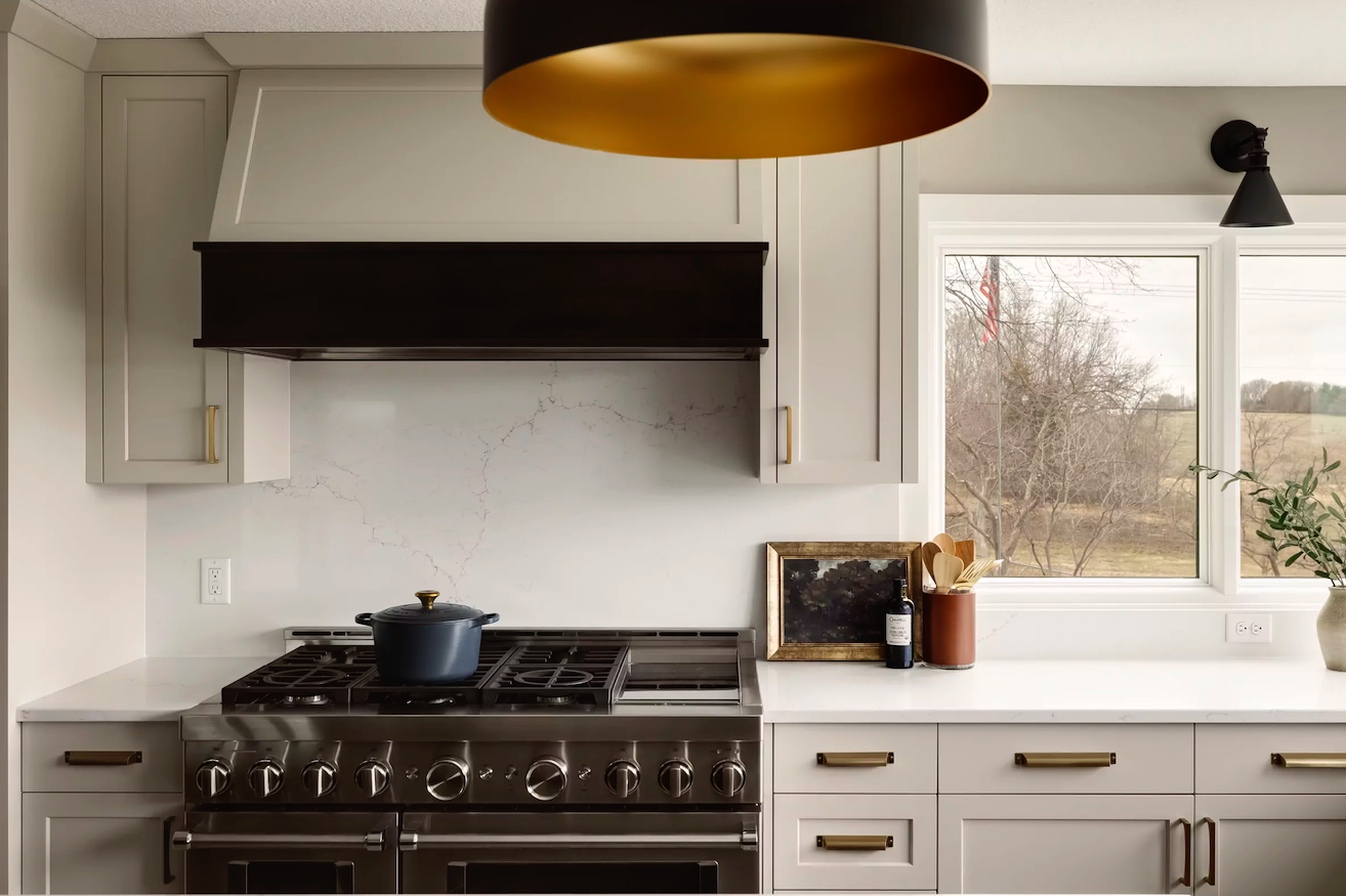 white marble countertop with white marble backsplash and stainless steel appliances in white kitchen