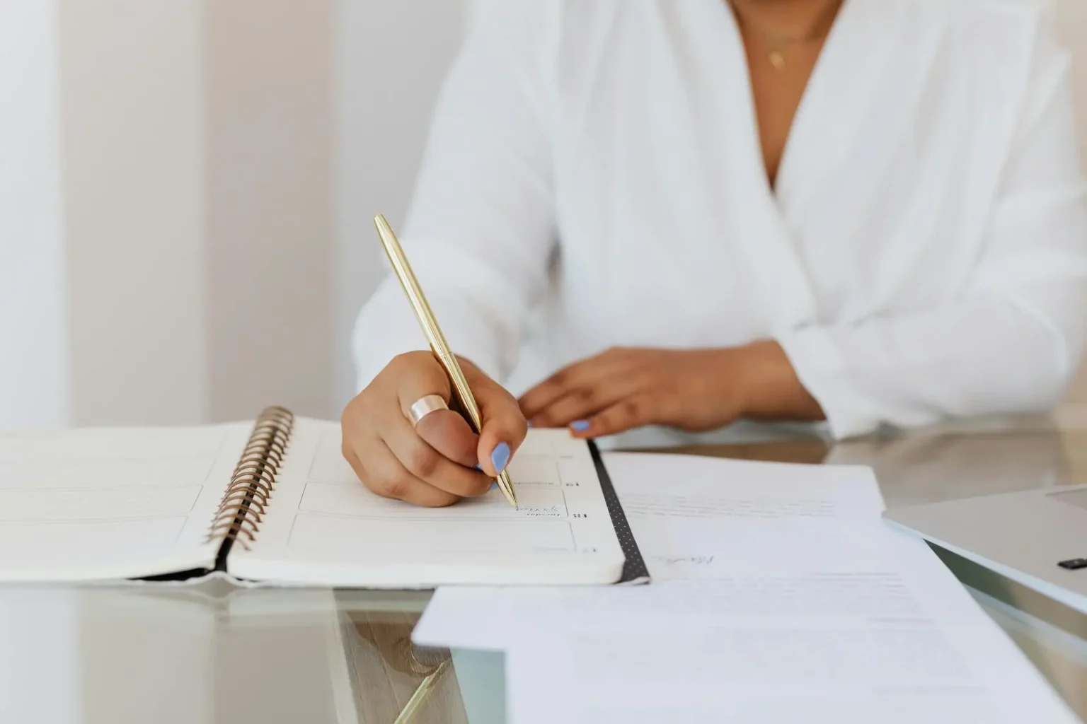 Woman sitting at a desk writing in a planner