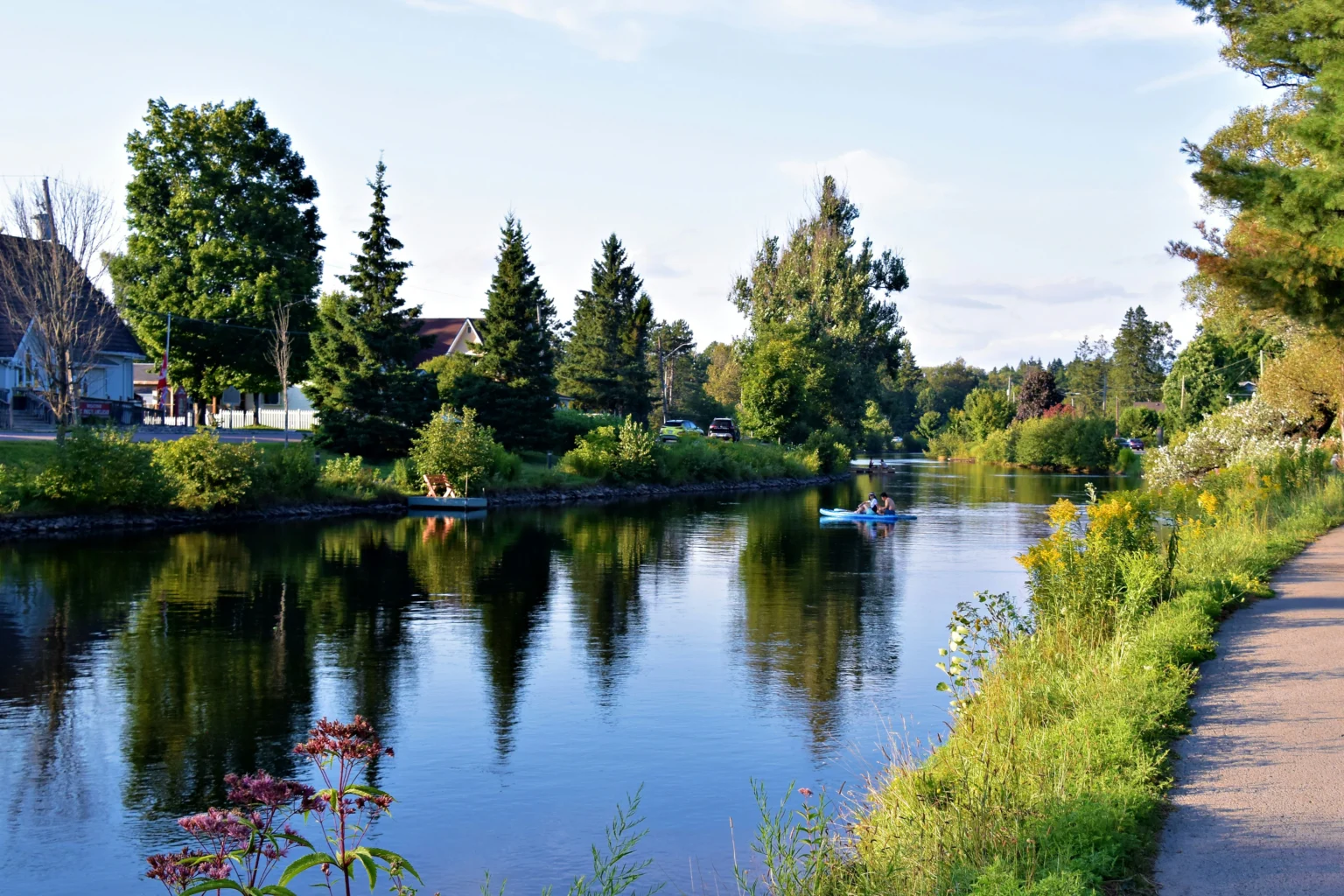 homes around a lake with a person kayaking
